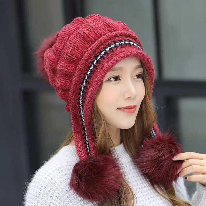 Woman in a knitted bobble hat with ear flaps